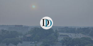 Image shows hazy, orange skies in Maryland during the 2023 Canadian wildfire. The image is overlapped with a blue transparent color and Dialogue & Discourse's logo