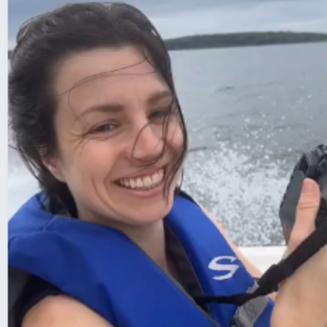 Alisha Camacho holds a camera while wearing a life jacket while aboard the Gunpowder Riverkeeper's boat.